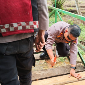 Tampak aparat polres Kerinci saat memperbaiki jembatan di desa Pengasi Baru.