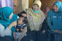 Ketua TP PKK Kabupaten Kerinci Novra Wenti Monadi saat menyerahkan  bantuan berupa beras, telur, dan uang tunai guna pemenuhan gizi keluarga