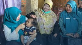 Ketua TP PKK Kabupaten Kerinci Novra Wenti Monadi saat menyerahkan  bantuan berupa beras, telur, dan uang tunai guna pemenuhan gizi keluarga