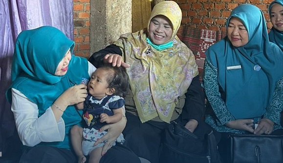 Ketua TP PKK Kabupaten Kerinci Novra Wenti Monadi saat menyerahkan  bantuan berupa beras, telur, dan uang tunai guna pemenuhan gizi keluarga