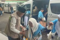 Wakil Wlikota Sungai Penuh, Azhar Hamzah saat membantu salah seorang jemaah haji berjalan menuju asrama haji