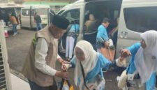 Wakil Wlikota Sungai Penuh, Azhar Hamzah saat membantu salah seorang jemaah haji berjalan menuju asrama haji