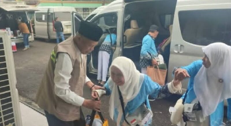 Wakil Wlikota Sungai Penuh, Azhar Hamzah saat membantu salah seorang jemaah haji berjalan menuju asrama haji